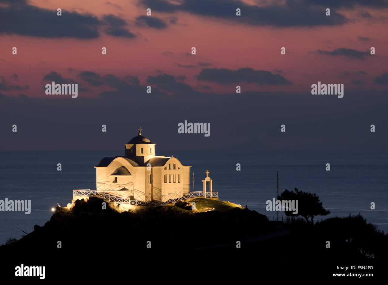 Chapelle de Saint Nicolas sur le coteau de Myrina port ville éclairée la nuit au coucher du soleil. Lemnos Limnos island, ou la Grèce. Fermer Banque D'Images