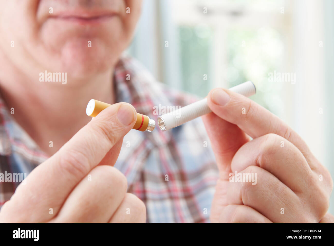L'homme à l'aide de la cigarette électronique pour arrêter de fumer Banque D'Images