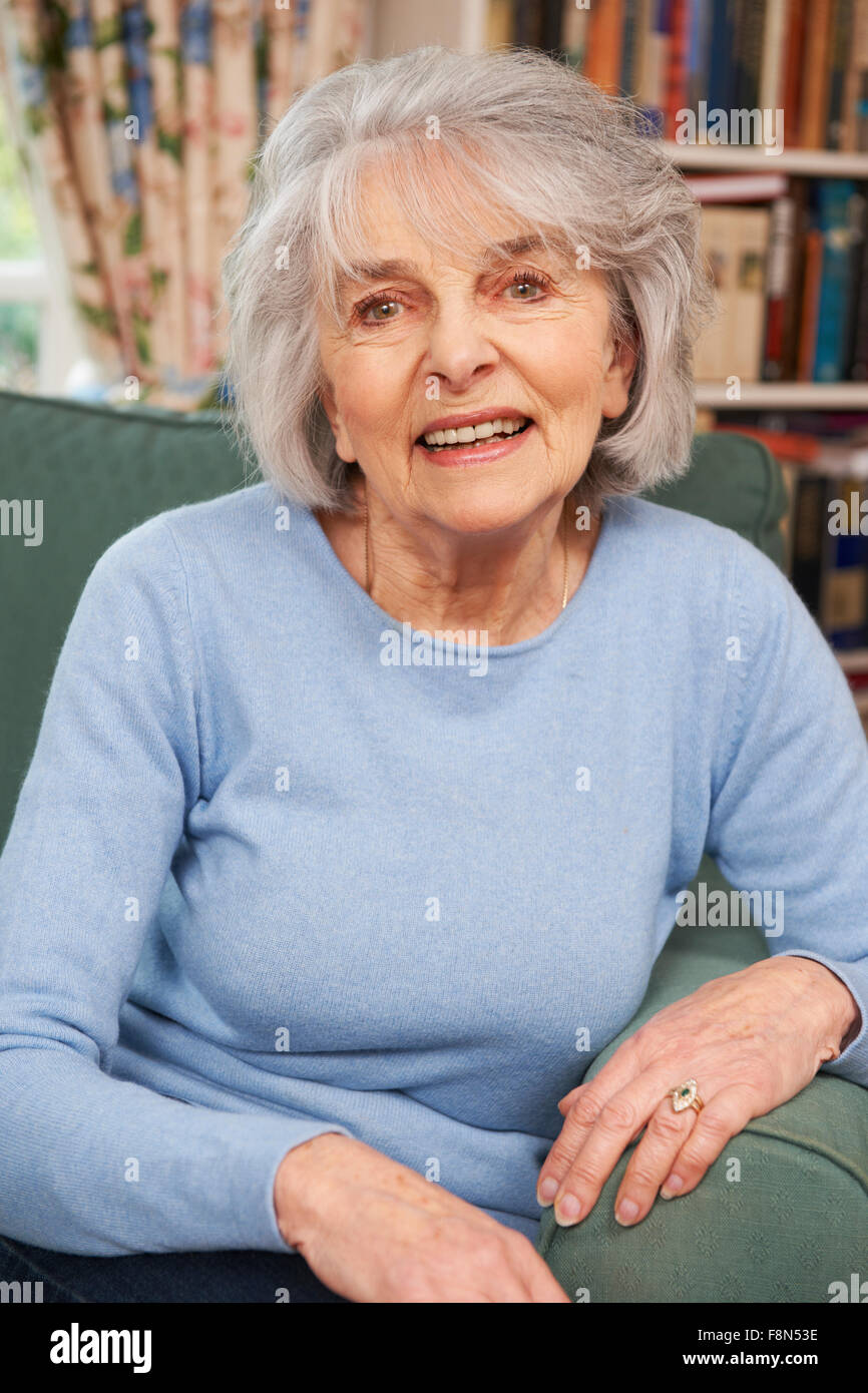Portrait Of Smiling Senior Woman Sitting in Armchair Banque D'Images