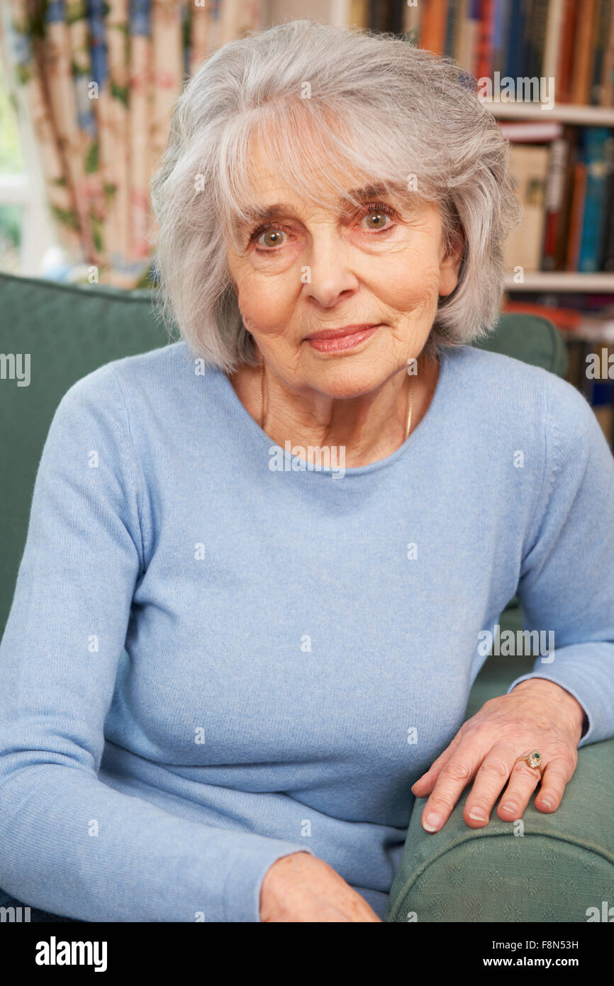Portrait Of Smiling Senior Woman Sitting in Armchair Banque D'Images