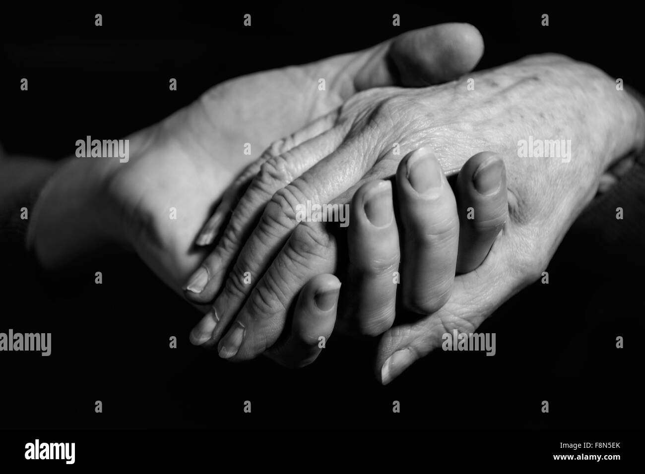 Shot monochrome de Jeune femme tenant la main de femme plus âgée Banque D'Images