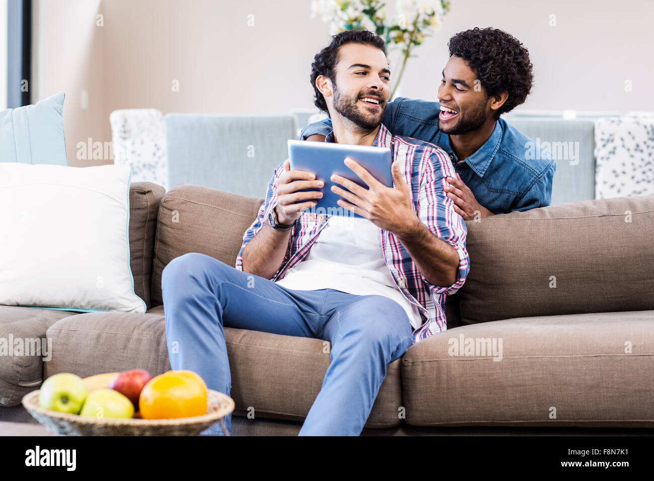 Happy gay couple using tablet Banque D'Images