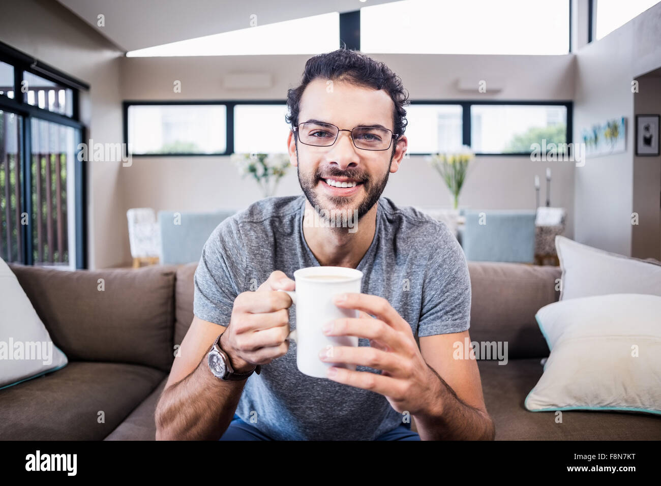 Portrait of smiling man holding white cup Banque D'Images