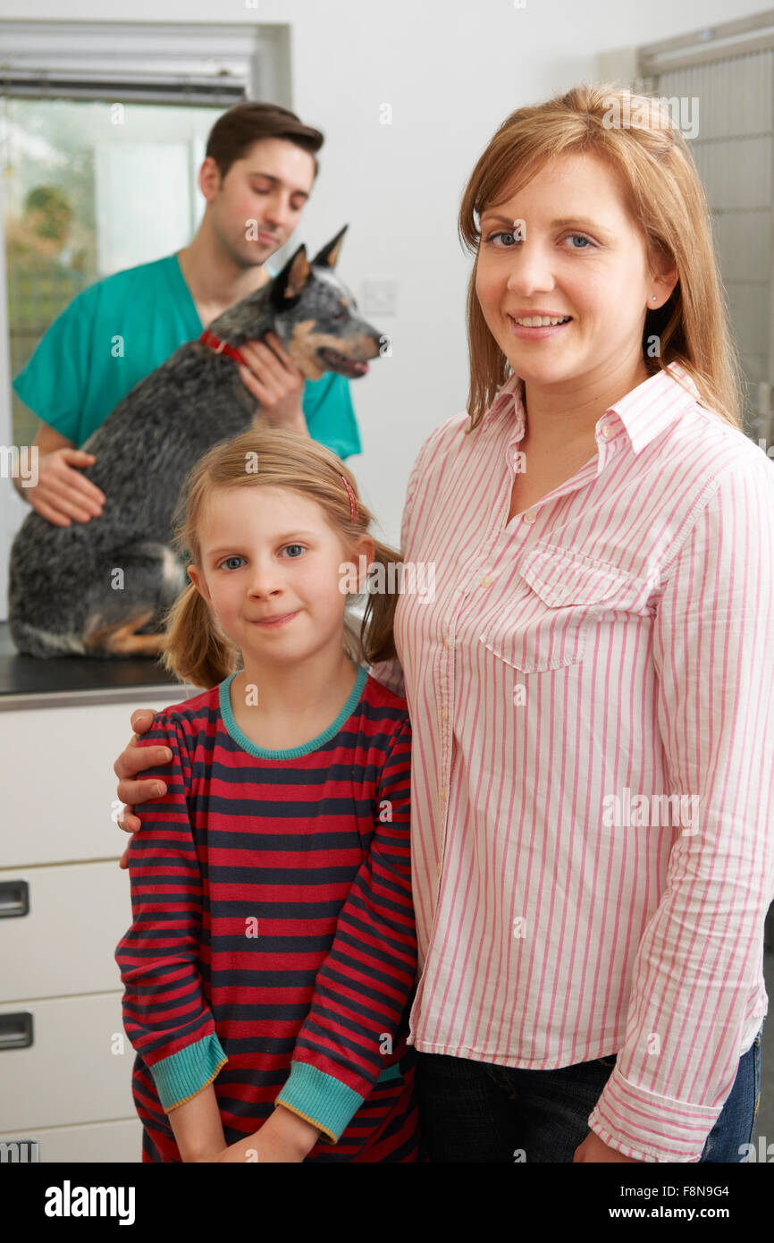 Mère et fille en tenant à l'examen de chien vétérinaires Banque D'Images