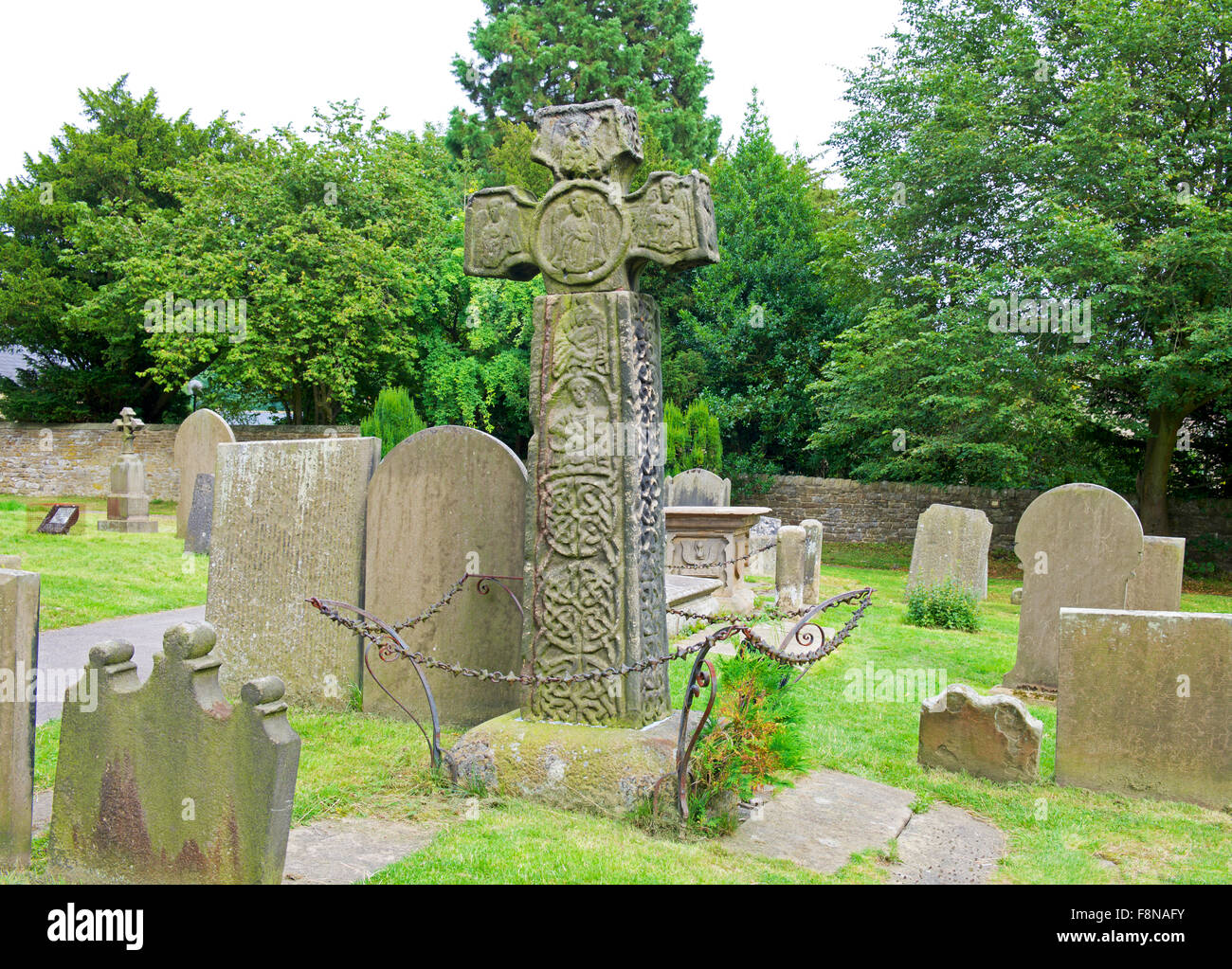 Croix celtique dans le cimetière de l'église Saint-Laurent, dans le village d'Eyam, parc national de Peak, Derbyshire, Angleterre, Royaume-Uni Banque D'Images