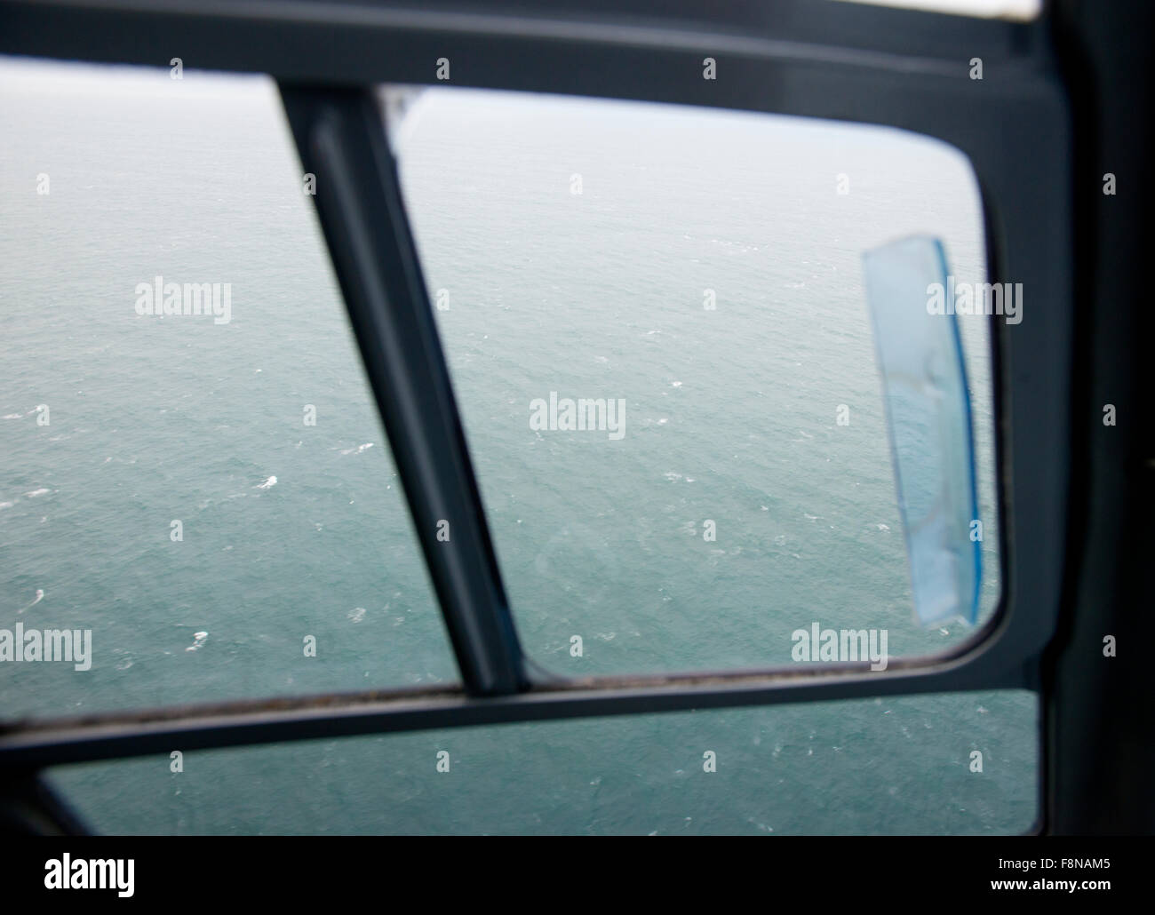 Dans le poste de pilotage d'un hélicoptère volant à partir de la terre ferme à l'île de Lundy, vue sur le côté de la mer Banque D'Images