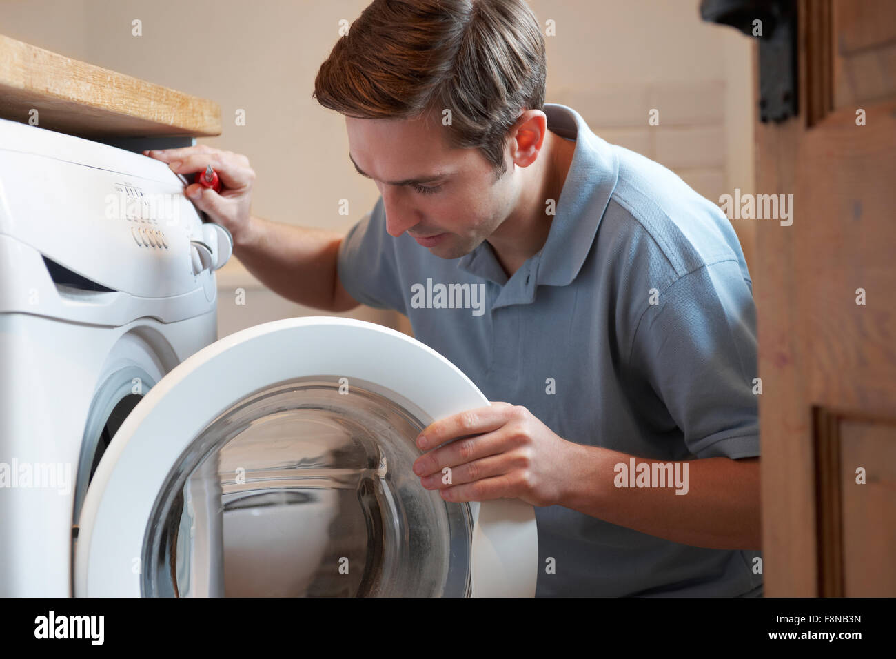 Réparer la machine à laver domestique ingénieur Banque D'Images