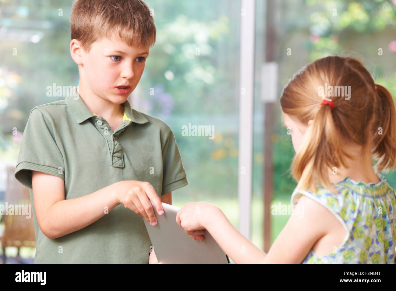 Garçon et fille se battre à Digital Tablet Banque D'Images