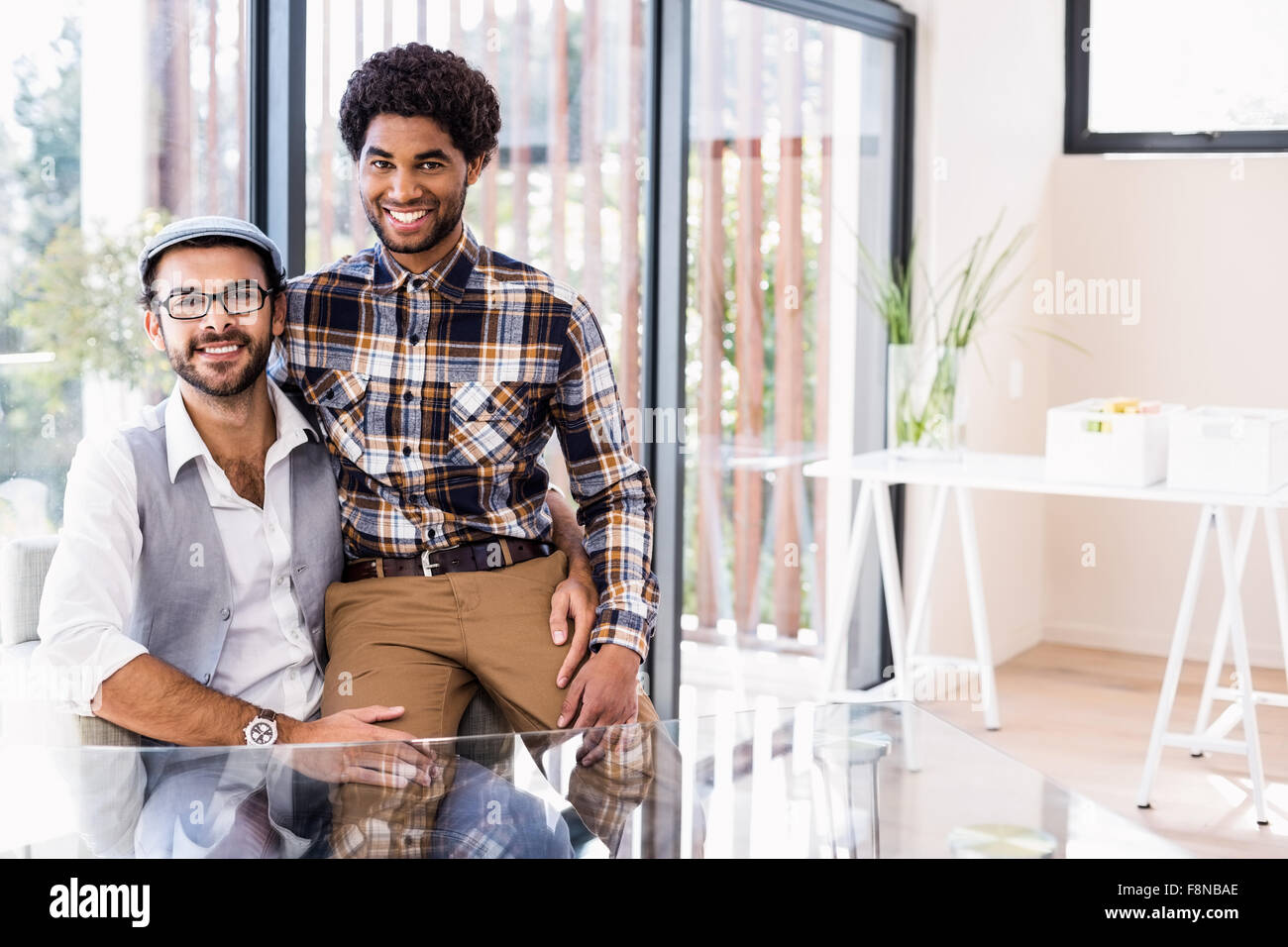 Happy gay couple sitting in living room Banque D'Images