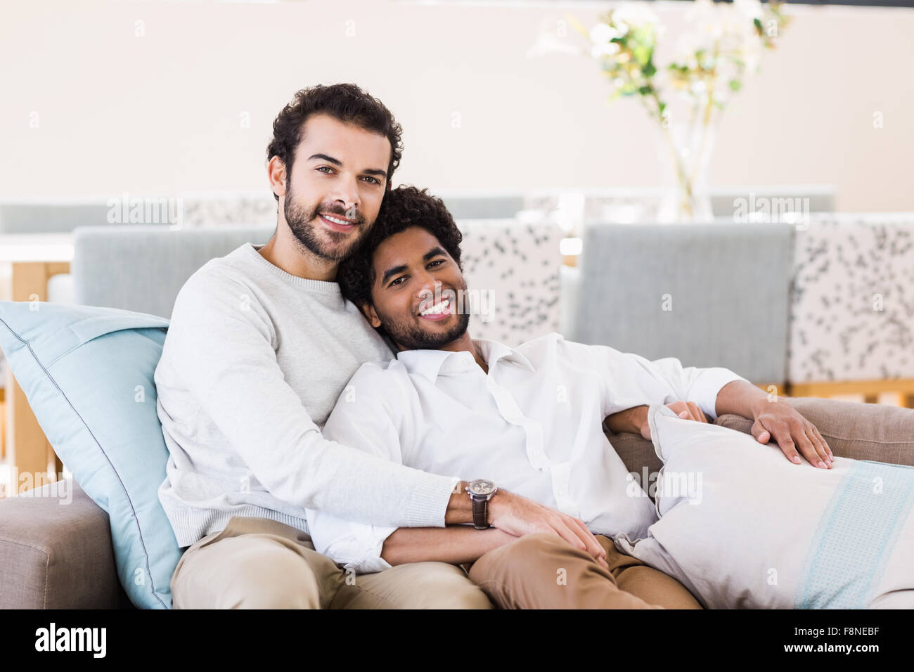 Happy gay couple relaxing on sofa Banque D'Images