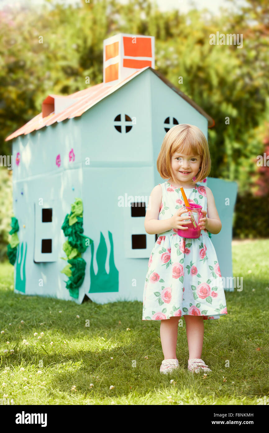 Jeune fille peinture Accueil faites maison en carton Banque D'Images