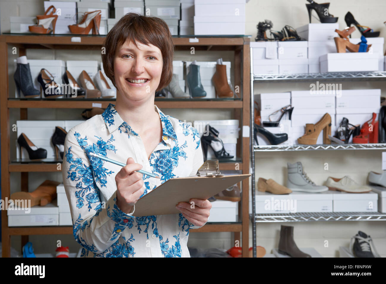 Femme propriétaire d'entreprise de chaussures en ligne avec presse-papiers Banque D'Images