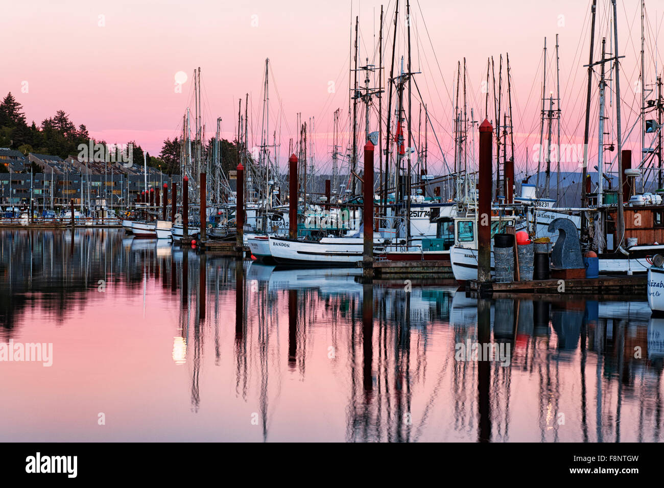 La pleine lune reflète dans Yaquina Bay avec la flotte de pêche de Newport sur la côte de l'Oregon central. Banque D'Images
