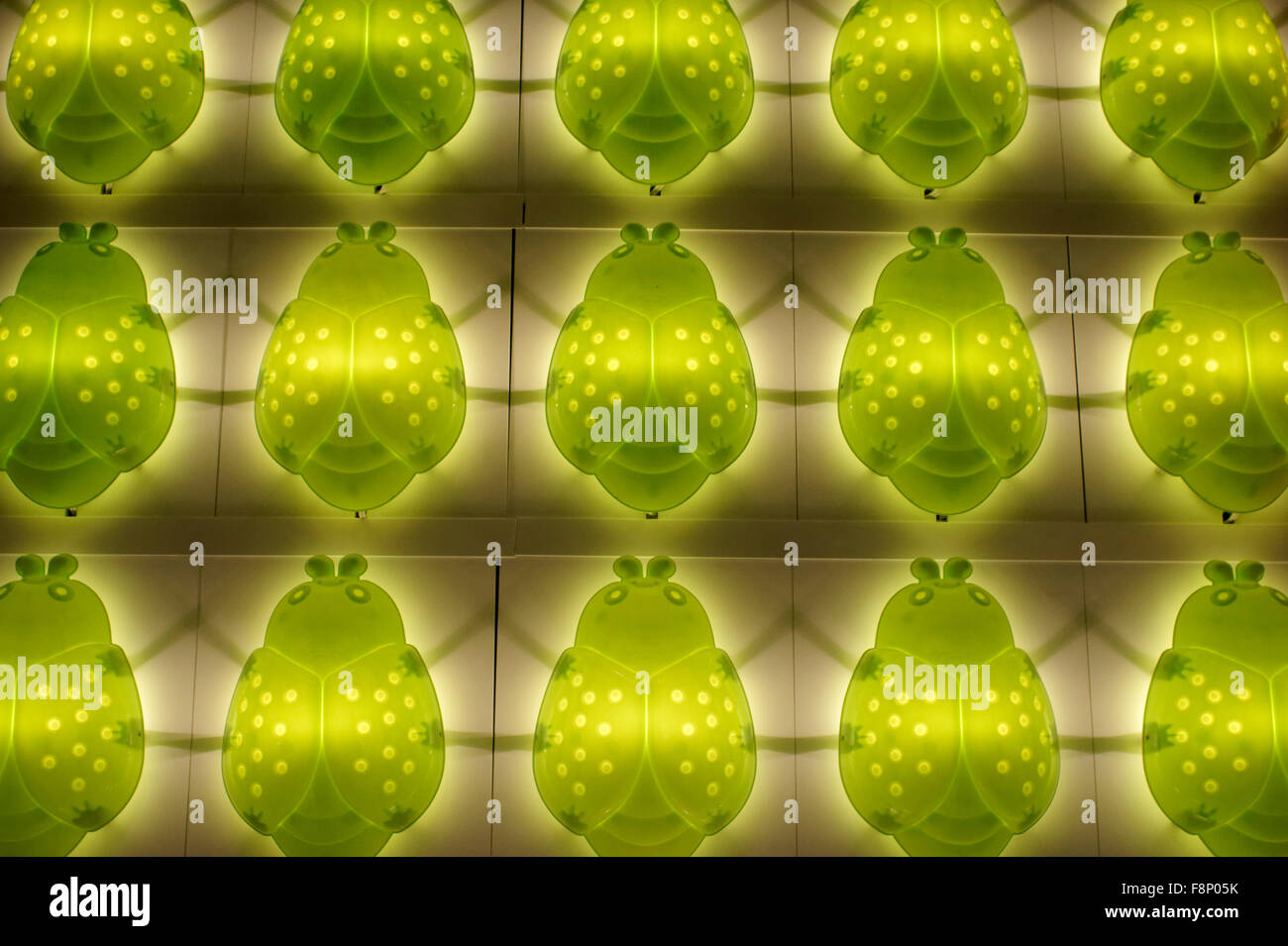 Des rangées de lumières nuit coccinelle vert décoratif sur un mur Banque D'Images
