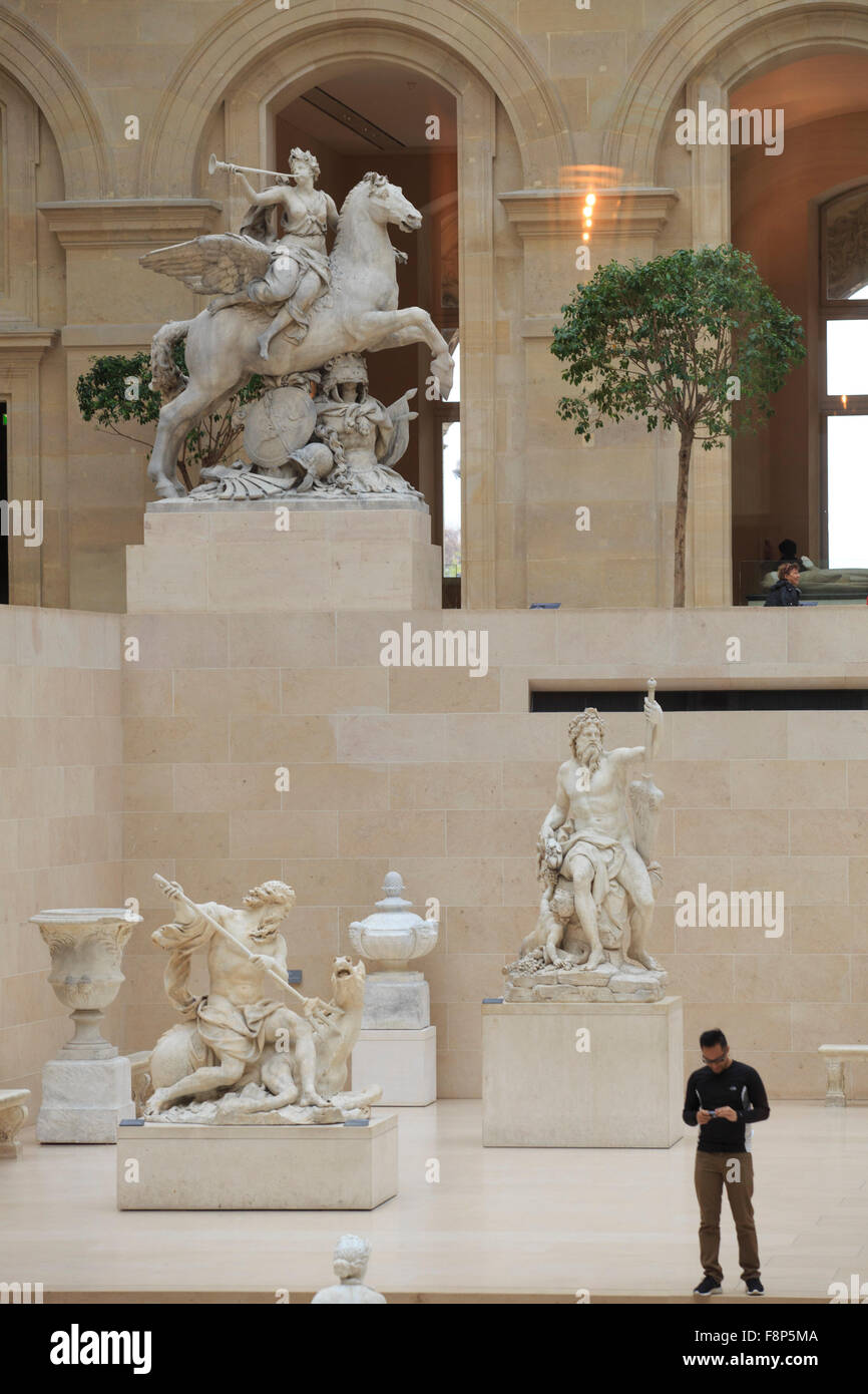 Des sculptures gigantesques de dieux grecs dans le foyer du Musée du Louvre à Paris, France Banque D'Images