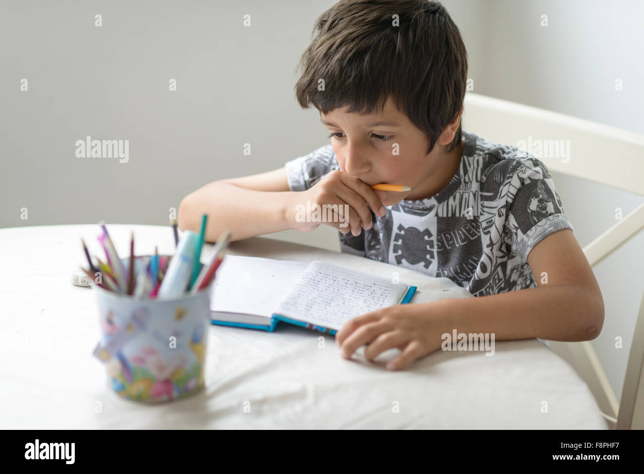 7 ans garçon écrit dans son lait Banque D'Images