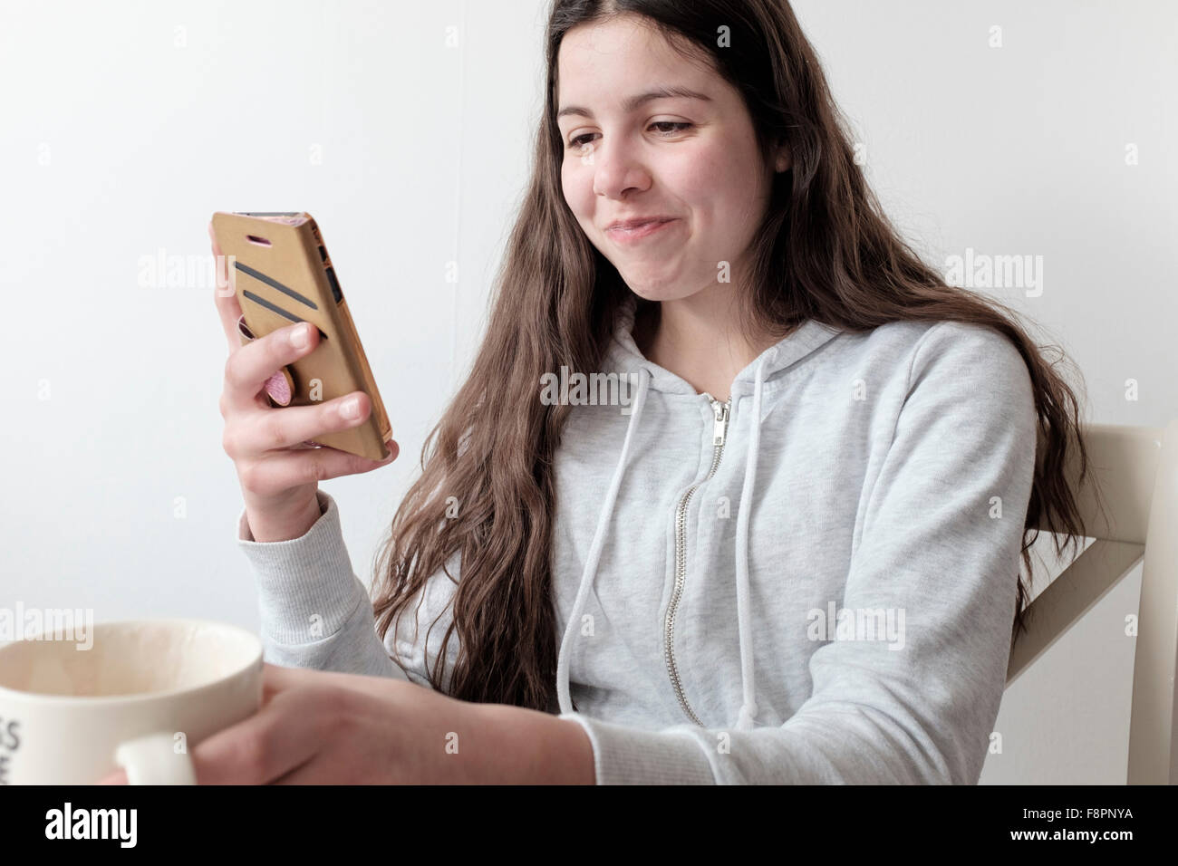 Teenage girl contrôler les médias sociaux sur son smart phone Banque D'Images