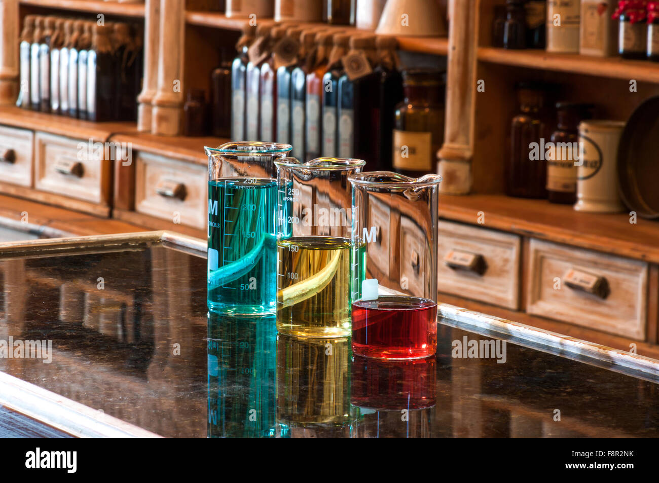 Close-up de trois verres berzelius contenant différentes quantités de liquide de couleur, un bleu, un jaune et un rouge, placé sur Banque D'Images