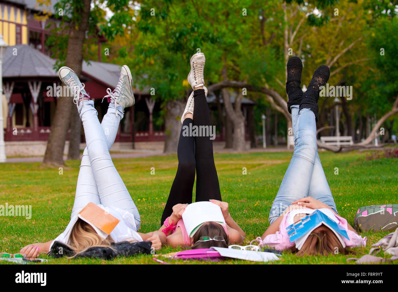 Jeune étudiant de lycée ou collège une pause de l'apprentissage sur l'herbe dans le parc avec ses pieds incliné dans l'air Banque D'Images