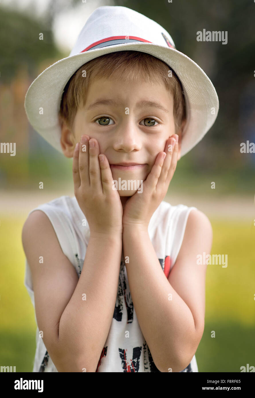 Portrait d'un garçon avec les mains sur le visage Banque D'Images