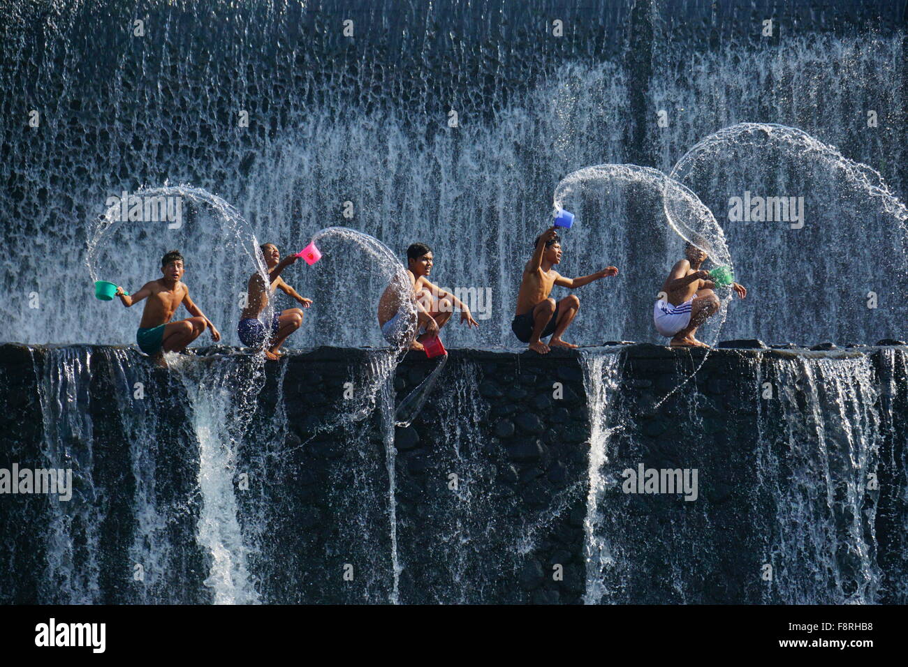 Cinq enfants aux projections d'eau, barrage Unda Tukad, Bali, Indonésie Banque D'Images