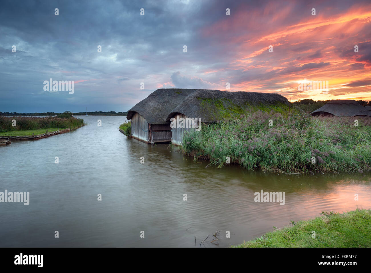 Plus de coucher de soleil spectaculaire bateau chaume maisons sur Hickling large à Norfolk Banque D'Images