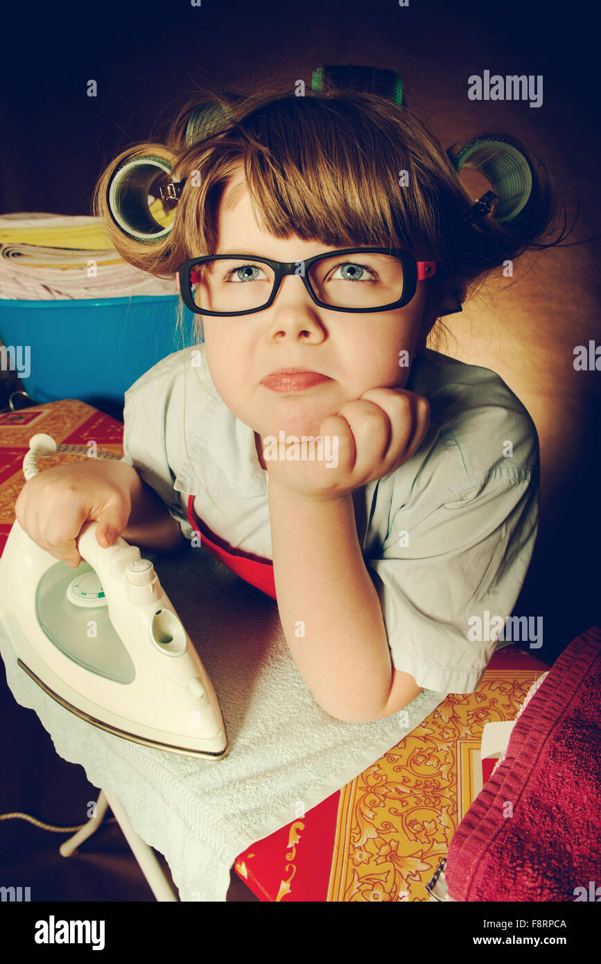 La petite femme avec diligence et d'une planche à repasser, vous êtes très fatigué. vintage-à Banque D'Images