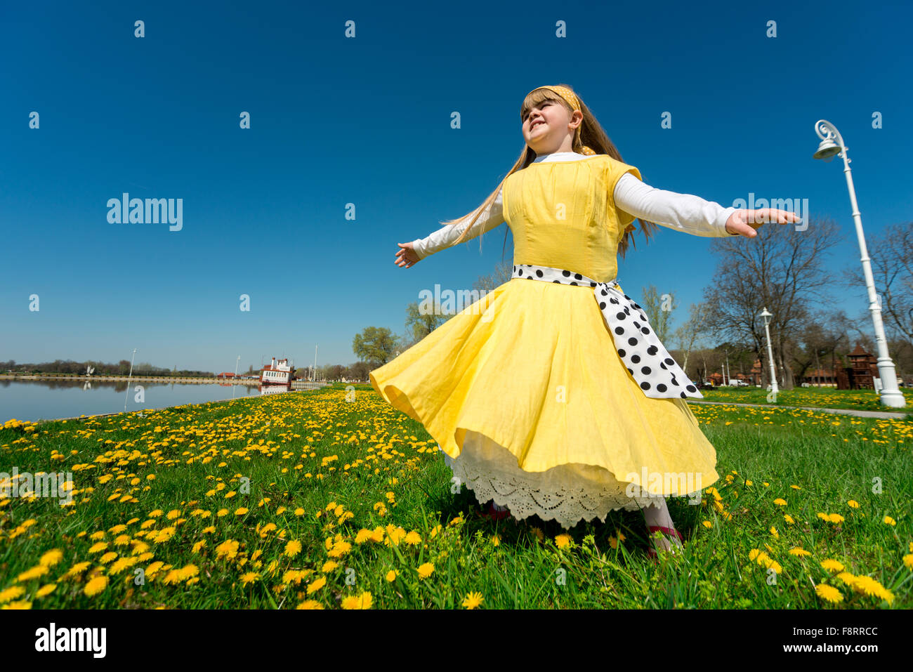 Petite fille jouant dans la nature, jouissant de la liberté tout en tournant sur son axe Banque D'Images