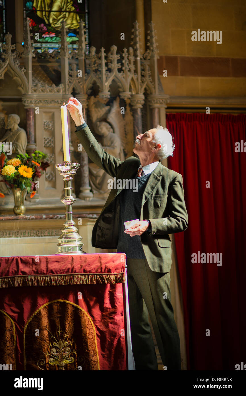 Religion / Eglise d'Angleterre : un membre d'une église allumer une bougie votive avant qu'un service de mariage, UK Banque D'Images