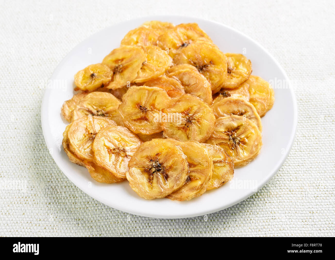 Chips de banane sur plaque blanche, vue en gros Banque D'Images