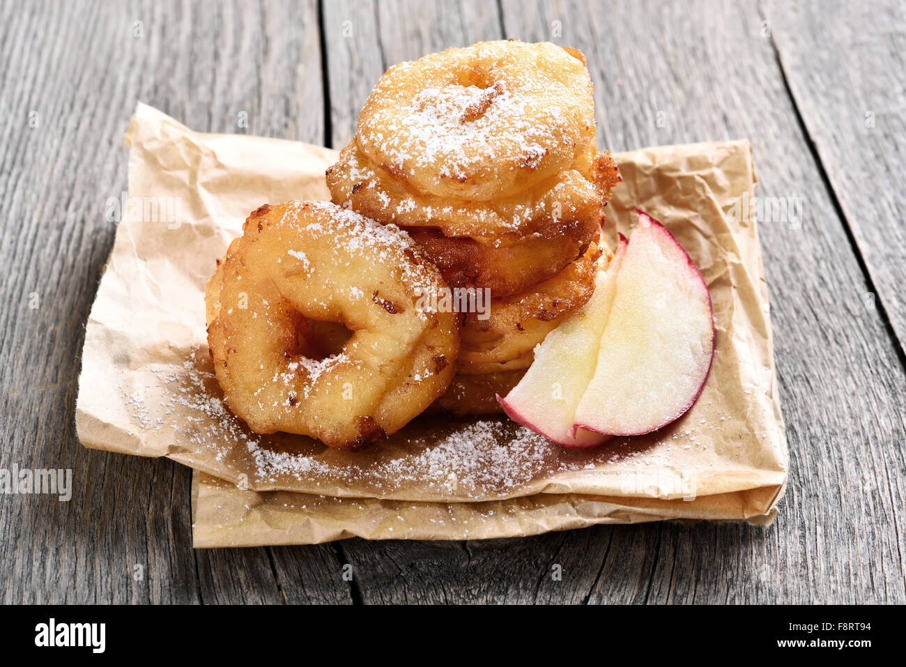 Apple rings sur papier cuisson sur table rustique Banque D'Images