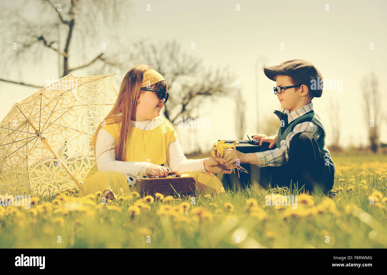 Courtiser une fille petit garçon du parc dans une prairie de fleurs.vintage-look Banque D'Images