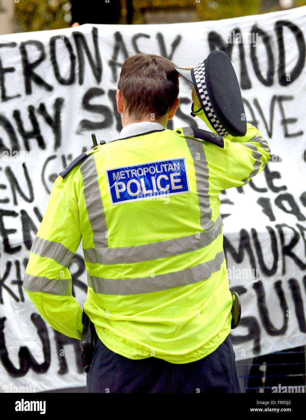 Londres, Angleterre, Royaume-Uni. agent de police gratte la tête comme à l'extérieur des manifestants Downing street, 2015 Banque D'Images