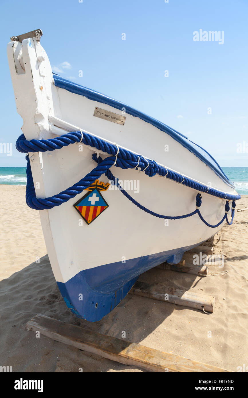 Calafell, Espagne - 20 août 2014 : bateau de pêche en bois blanc s'étend sur une plage de sable, mer Méditerranée, Côte d'Espagne Banque D'Images