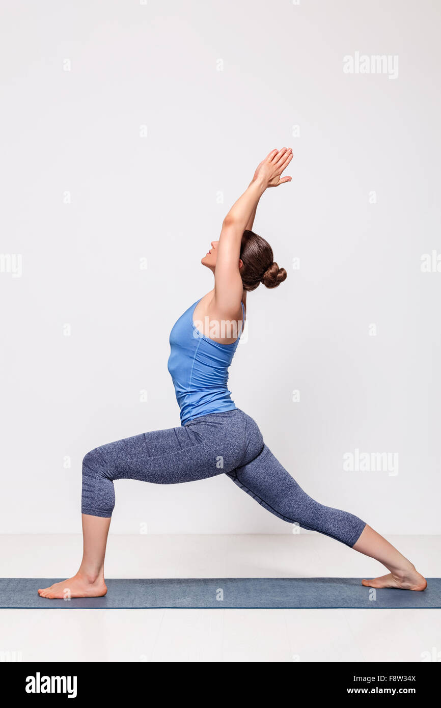 Femme sportive pratique le yoga asana posture du guerrier Banque D'Images