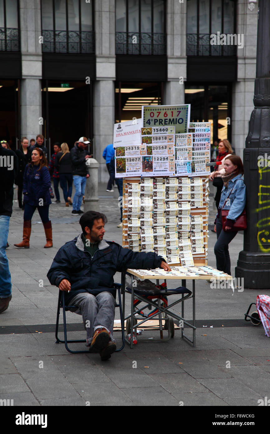 Madrid, Espagne 11 décembre 2015 : un homme est assis à côté de son stand vendant des billets pour la loterie de Noël sur la Plaza Puerta del sol dans le centre de Madrid. La loterie de Noël espagnole est l'une des plus anciennes au monde et la plus grande au monde en termes de paiement total. Le ticket gagnant est connu sous le nom de 'El Gordo' ('le Big One' ou 'le Fat One'). Crédit : James Brunker / Alamy Live News Banque D'Images