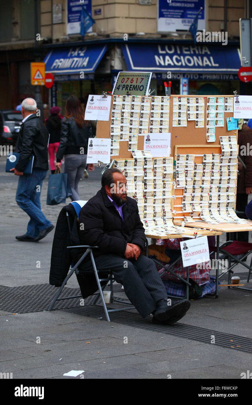 Madrid, Espagne 11 décembre 2015 : un homme est assis à côté de son stand vendant des billets pour la loterie de Noël sur la Plaza Puerta del sol dans le centre de Madrid. La loterie de Noël espagnole est l'une des plus anciennes au monde et la plus grande au monde en termes de paiement total. Le ticket gagnant est connu sous le nom de 'El Gordo' ('le Big One' ou 'le Fat One'). Crédit : James Brunker / Alamy Live News Banque D'Images