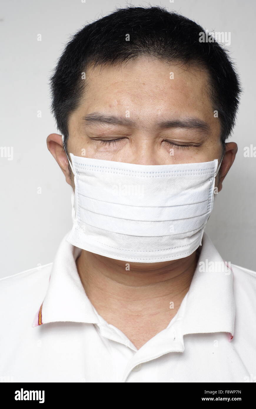 Asian man in medical portrait masque les yeux fermés Banque D'Images