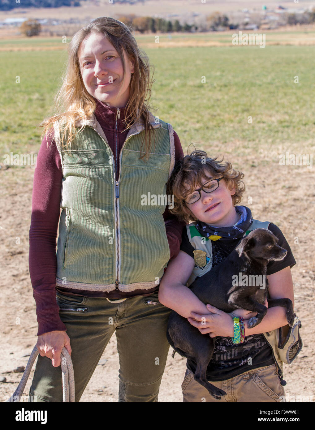 Belle mère, fils et chien posent à l'extérieur sur ranch pour une photographie Banque D'Images
