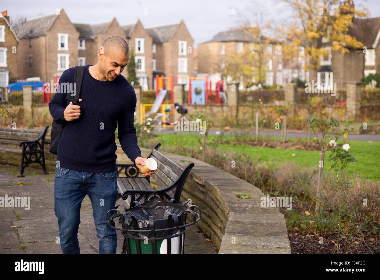 L'homme de jeter les ordures dans le bac dans un parc Banque D'Images