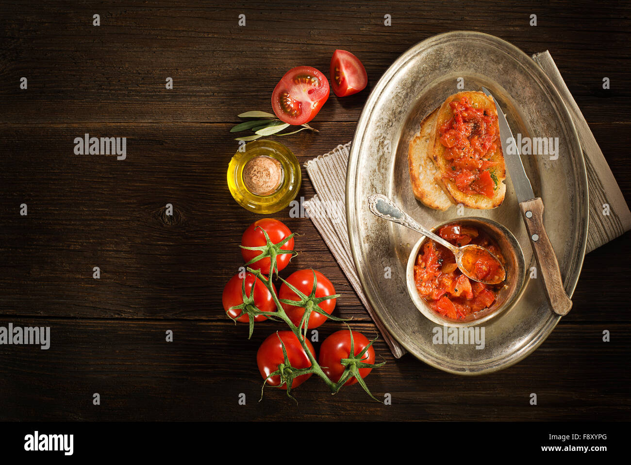 Pain grillé à la tomate et l'huile d'olive sur fond de bois. Banque D'Images
