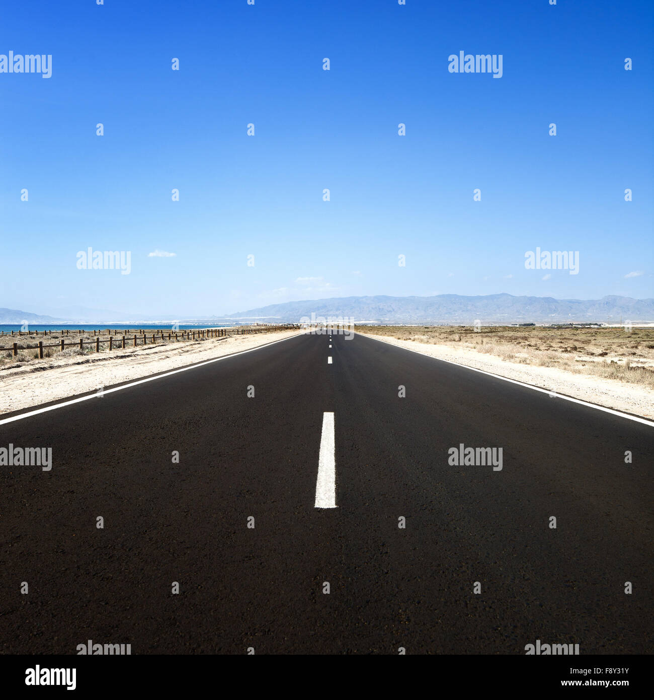 Route droite dans un désert marin dans une journée ensoleillée. Cabo de Gata, en Andalousie, espagne. Banque D'Images