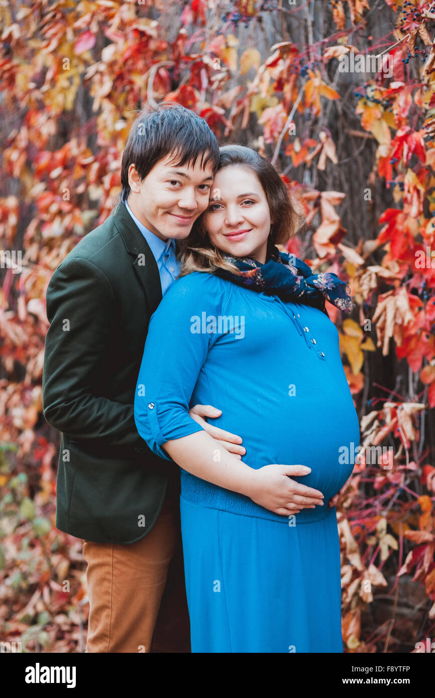 Femme enceinte avec son mari qui pose pour l'appareil photo Banque D'Images