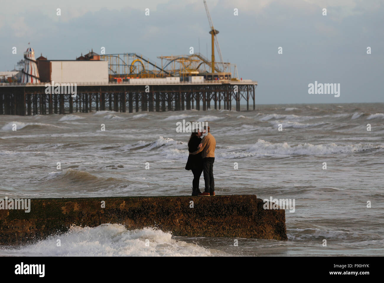 Un couple baiser sur une jetée en face de la jetée de Brighton à Brighton, UK Banque D'Images