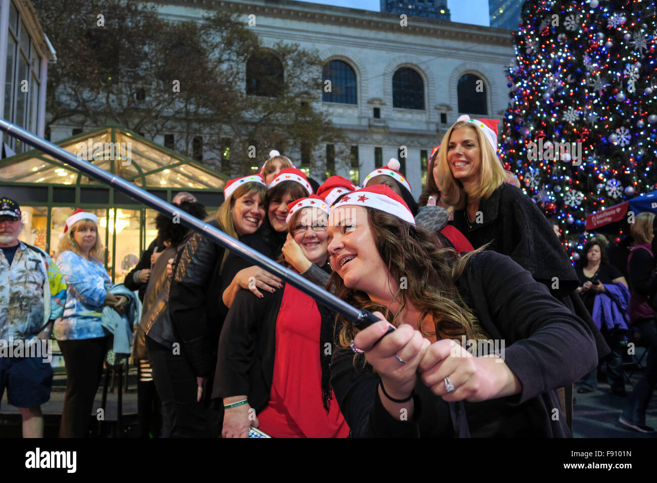 New York City, USA. 12 décembre 2015. SantaCon est devenu très un populaire pub crawl. Un groupe de femmes posent avec Bryant Park's Christmas Tree dans Midtown Manhattan. Credit : Patti McConville/Alamy Live News Banque D'Images