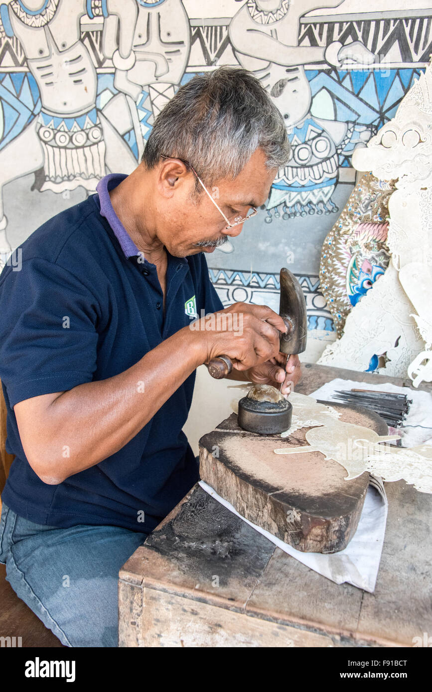 Man Making Wayang Kulit (marionnettes) en cuir, Yogyakarta, Indonésie Banque D'Images