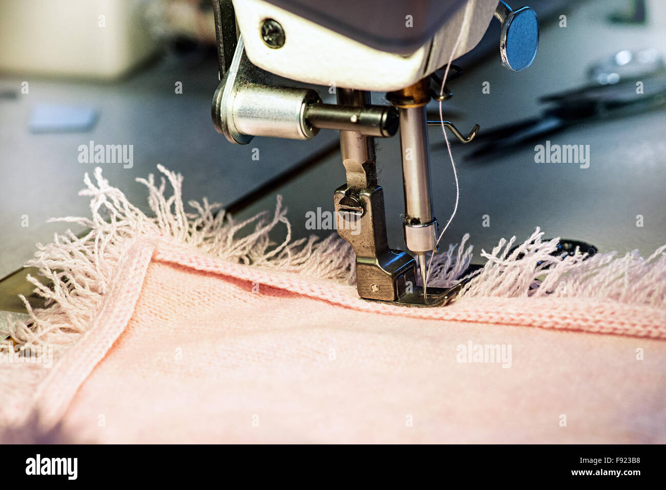 Close Up de l'aiguille de machine à coudre apposition Fringe Bordure sur vêtement Rose Banque D'Images