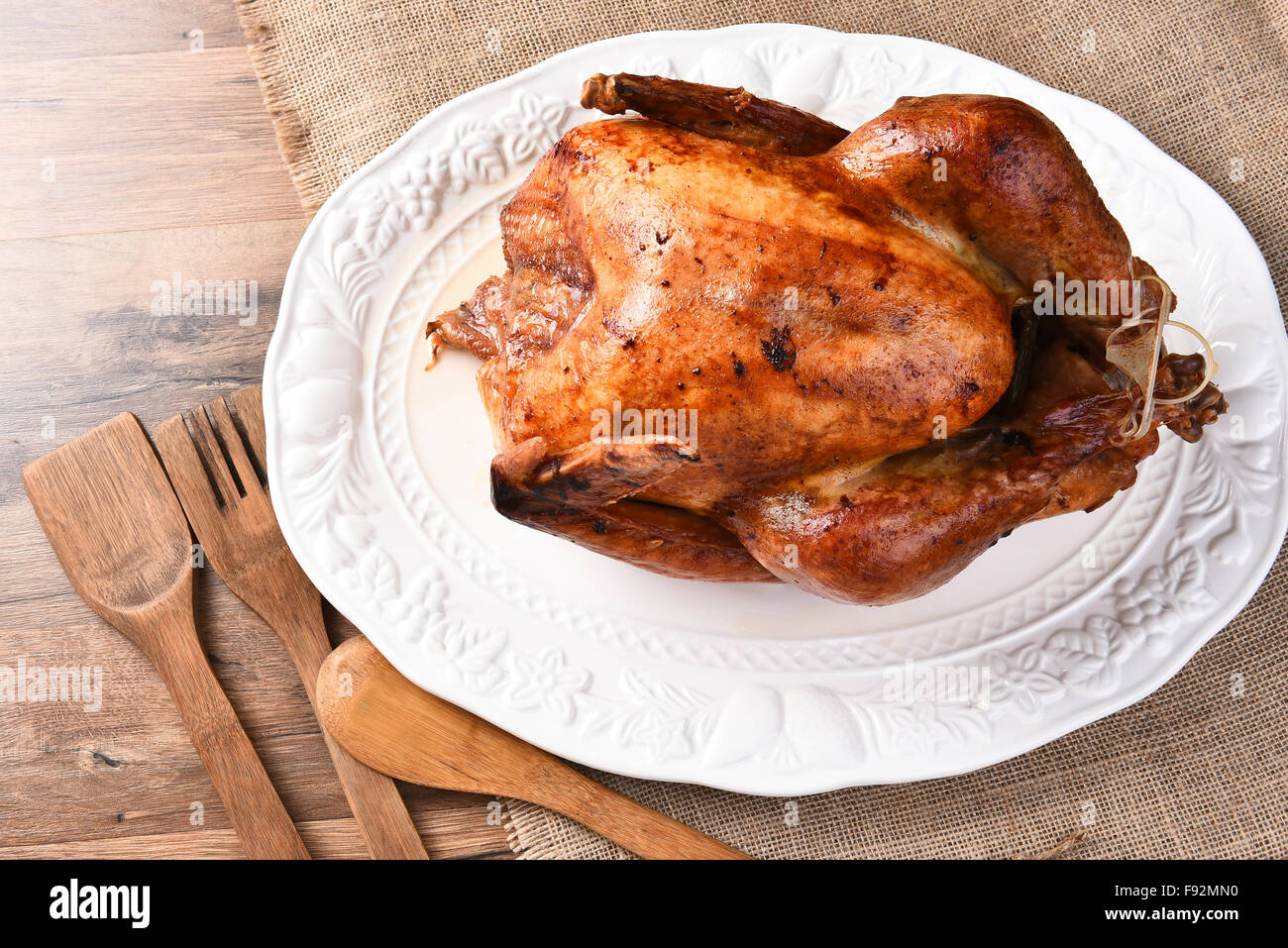 Portrait d'une dinde de Thanksgiving rôti frais sur un plateau de table blanc toile tissu et outils. Banque D'Images