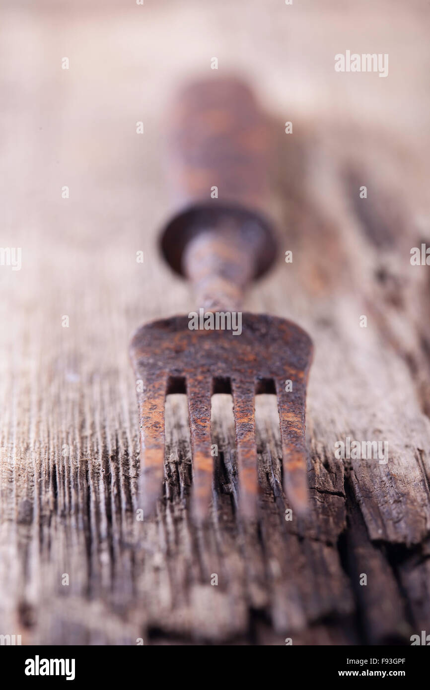 Old rusty fourche sur une planche en bois libre Banque D'Images