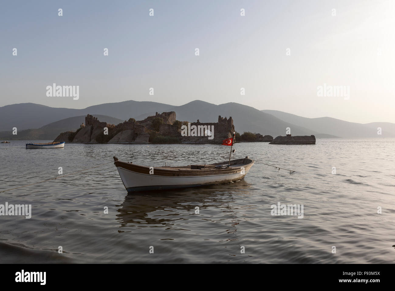 Kapıkırı beach avec les bateaux de pêche dans le lac Bafa et un château dans une petite île rocheuse, Turquie Banque D'Images